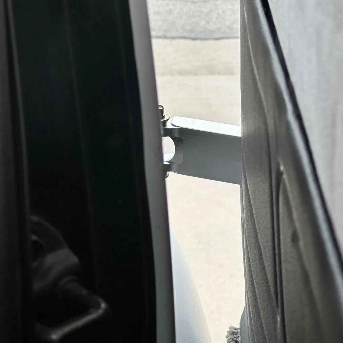Photo from inside a van looking out and back at installed hinge.
